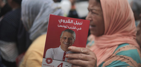 Eine Unterstützerin hält Wahlkampfmaterial des inhaftierten tune