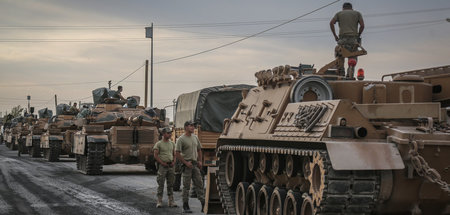 Türkische Soldaten und die Militärfahrzeuge stehen in der türkis