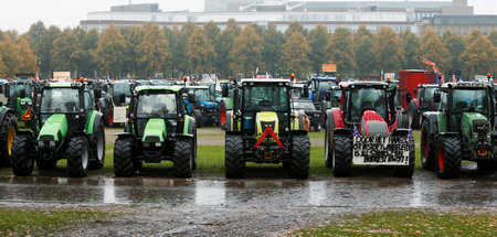 Landwirte mit ihren Traktoren stehen bereit, um Verkehr in Den H...