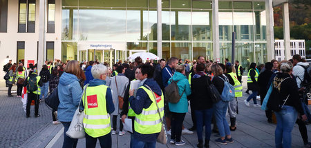 Mitarbeiter stehen beim Warnstreik vor dem Haupteingang am Unive...