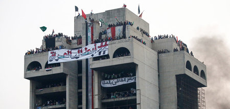 Demonstranten am Montag auf einem Gebäude in Bagdad