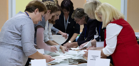 Mitglieder der lokalen Wahlkommission vor der Auszählung der Sti...