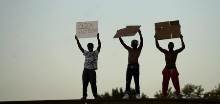 Demonstranten protestieren auf dem Dach eines Geschäftes gegen r...