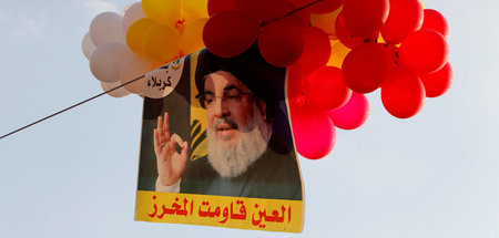 Hisbollah-Chef Hassan Nasrallah auf einem Bild in der Nähe der l...