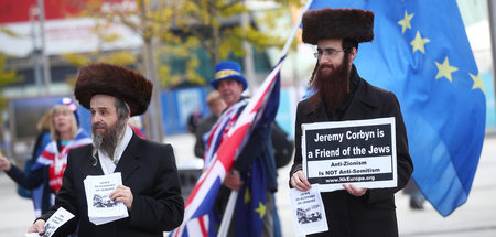 Zwei Männer in der Kleidung orthodoxer Juden solidarisieren sich...