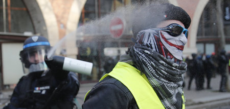 Ein Polizist sprüht einem Demonstranten der »Gelbwesten« eine Fl...