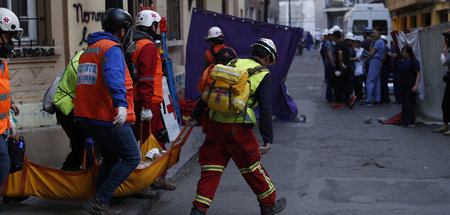 Sanitäter tragen einen verletzten Demonstranten aus der Gefahren...