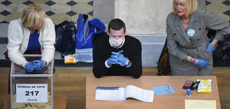 Abstimmen in Zeiten von Corona: Freiwillige Wahlhelfer mit Maske... Abstimmen in Zeiten von Corona: Freiwillige Wahlhelfer mit Maske...
