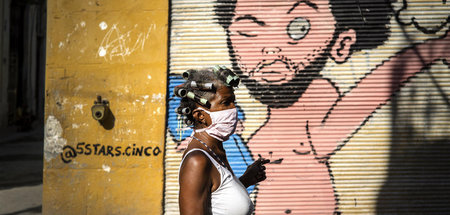 Im Zweifel gesünder: Kubanerin mit Schutzmaske vor Streetart-Kun...