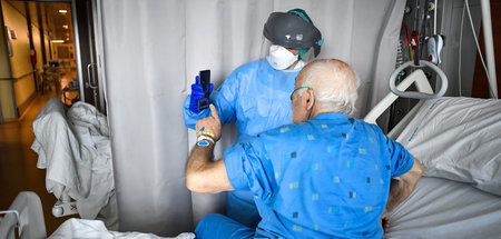 Ein Covid-19-Patient macht von seinem Krankenbett aus mit Hilfe 