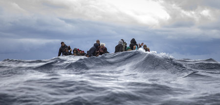Flüchtende bei schwerem Seegang in einem überfüllten Holzboot vo