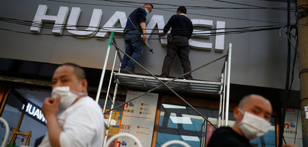 Arbeiter montieren ein Huawei-Logo in Beijing (24.4.2020) – US-A...