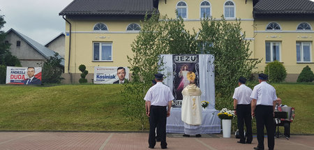 Altar in der polnischen Stadt Bazyny. Im Hintergrund Wahlplakate...