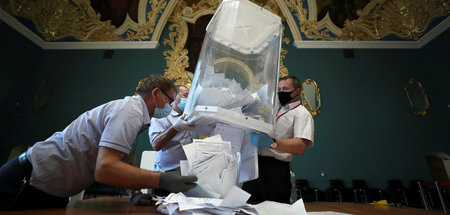 Mitglieder einer lokalen Moskauer Wahlkommission leeren nach der...