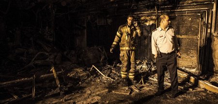 Ein Feuerwehrmann (l.) bei den Löscharbeiten nach einer Explosio...