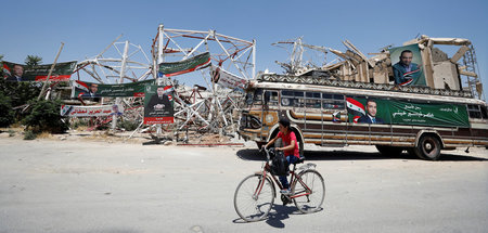 Kandidatenplakate an zerstörten Häuserfassaden wie hier in Duma ...