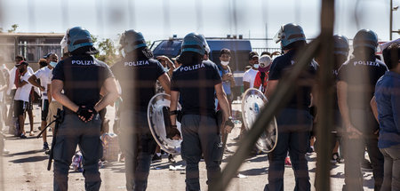 Polizisten verstellen am Montag in Porto Empedocle Flüchtlingen ...