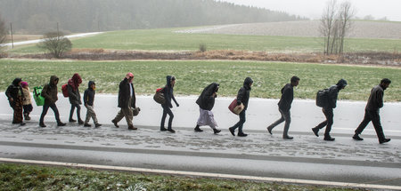 Flüchtlinge passieren im Schneeschauer die Grenze zu Deutschland...