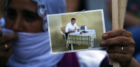 Eine Unterstützerin der HDP zeigt ein Foto von Selahattin Demirt...