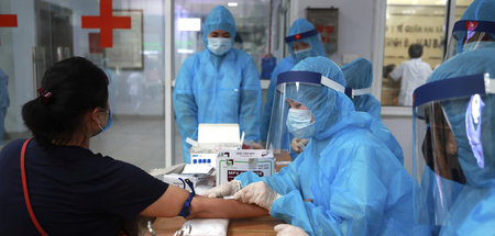 Beschäftigte der Gesundheitsbehörden in Hanoi führen Covid-19-Te...