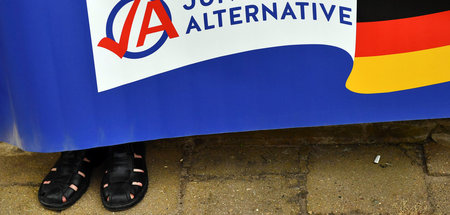 Ein Mitglied der JA hält ein Banner der Organisation (Apolda, 17...