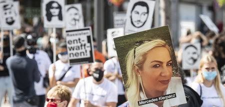 Teilnehmer der Kundgebung am Samstag in Hanau mit Bildnissen der...