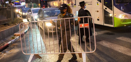 Ein israelischer Grenzpolizist errichtet in Bnei Brak vor einer ... Ein israelischer Grenzpolizist errichtet in Bnei Brak vor einer ...