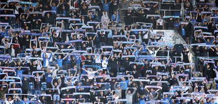 Fußballfans des FC Hansa Rostock stehen auf den Tribünen im Osts