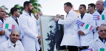 Kubanische Mediziner mit einem Bild von Fidel Castro vor ihrem F