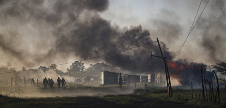 Eine Hütte brennt, während die Polizei am Donnerstag die Räumung