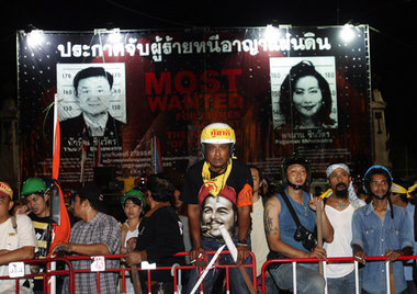Demonstranten in Bangkok vor einer Wand mit Fahndungsbildern des...
