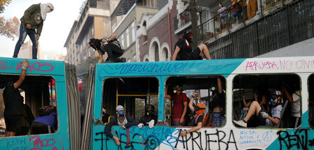 Demonstranten entern bei einem Protest in Santiago einen ausgebr...