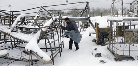 Ein Flüchtling in den schneebedeckten Überresten des ausgebrannt...