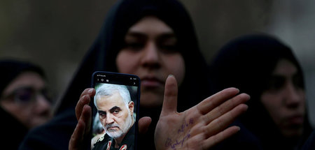 Iranerin mit einem Porträtfoto Qassem Soleimanis während eines P...