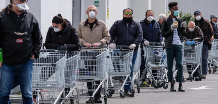 Einkaufen in Pandemiezeiten: Lange Schlangen vor einem Supermark...
