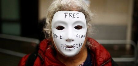 Die anonymisierende Maske deutet es an: Im Fall Assange geht es ...
