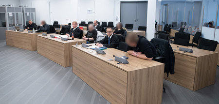 Die Angeklagten (gepixelt) mit ihren Anwälten vor Prozessbeginn 