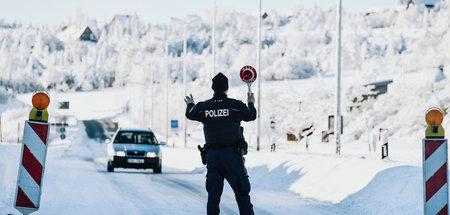 Ein Polizist fordert am Sonntag an der tschechischen Grenze eine...