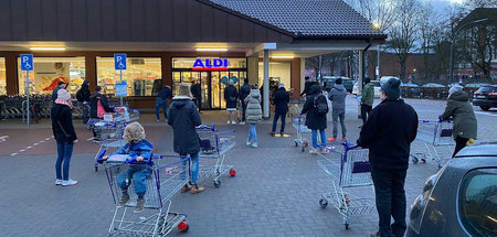 Anstehen mit Abstand: Kunden warten auf die Öffnung einer Aldi-F...