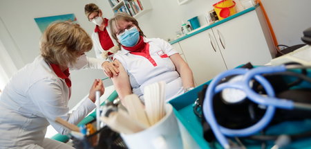 Eine Krankenschwester lässt sich in einer Arztpraxis mit dem Mit... Eine Krankenschwester lässt sich in einer Arztpraxis mit dem Mit...