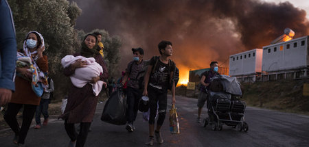 Geflüchtete fliehen mit ihren Habseligkeiten vor den Feuern im F...