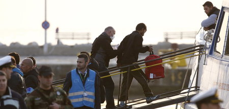 Tatkräftige Hilfe: Ein Frontex-Mitarbeiter führt einen Geflüchte...