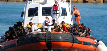 Flüchtlinge in einem Rettungsboot vor der italienischen Insel La... Flüchtlinge in einem Rettungsboot vor der italienischen Insel La...