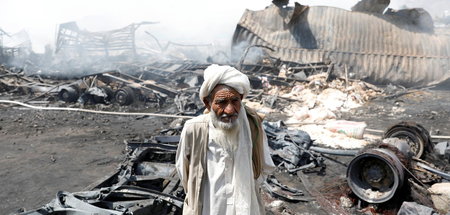 Lkw-Besitzer Dad Mohammad, 78, neben den Überresten seines Fahrz...