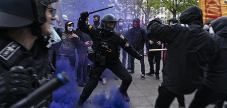 Ein Polizist greift mit dem Teleskopschlagstock linke Demonstran...