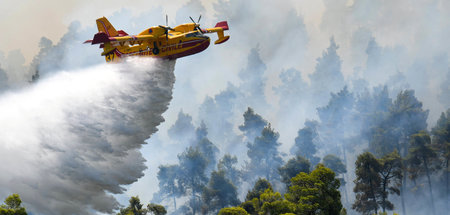 Dörfer schützen: Ein Löschflugzeug versucht einen Waldbrand nahe... Dörfer schützen: Ein Löschflugzeug versucht einen Waldbrand nahe...