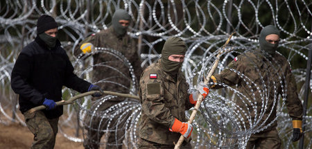 Gewissenskonflikt? Polnische Soldaten mit Stacheldraht an der Gr...
