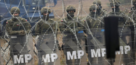 Polnische Soldaten hinter Stacheldraht an der Grenze zu Belarus ...