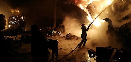 Feuerwehrleute im Kampf gegen die Flammen im Containerlager des ...