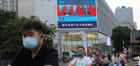 Straßenszene in Beijing mit Liveübetragung eines Treffens der Pr...